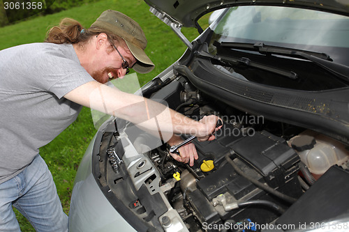 Image of mechanic repairs a car on the road