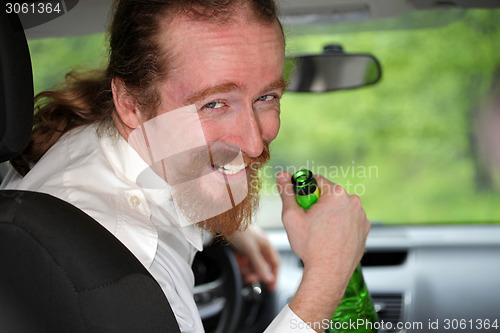 Image of Drunk man in car with a bottle alcohol