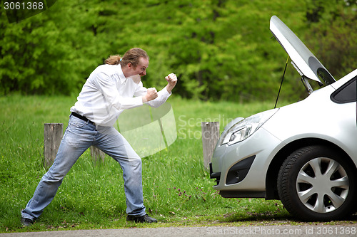 Image of Driver furious a broken car by the road  