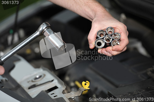 Image of Auto mechanic with chrome plated wrench in closeup