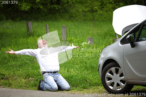 Image of Driver furious a broken car by the road  