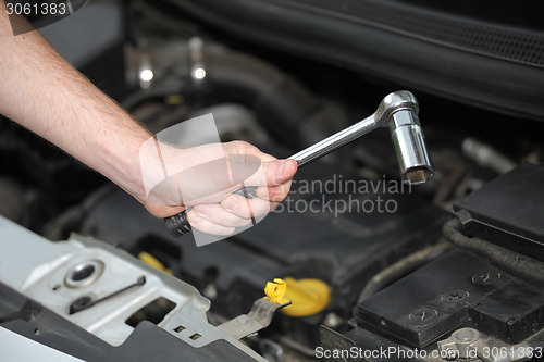 Image of Auto mechanic with chrome plated wrench in closeup