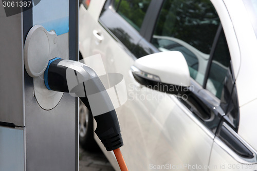 Image of Electric car being charged at the station, close up of the power