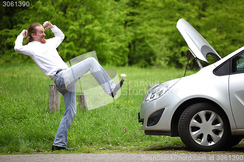 Image of Driver furious a broken car by the road  