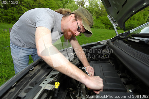 Image of mechanic repairs a car on the road