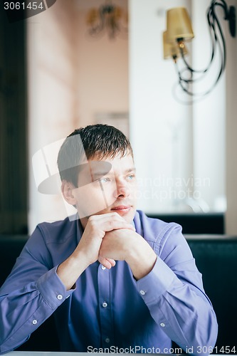 Image of Handsome Thinking Man In Shirt Sitting In Cafe