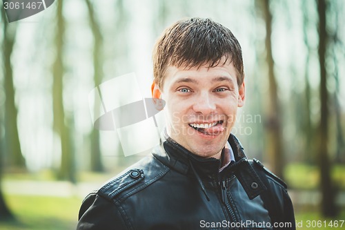 Image of Close Up Young Handsome Man Shows Tongue. 