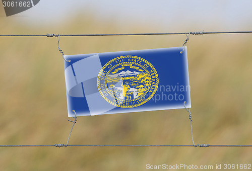 Image of Border fence - Old plastic sign with a flag