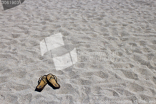 Image of Flip flop sandals on the sandy beach