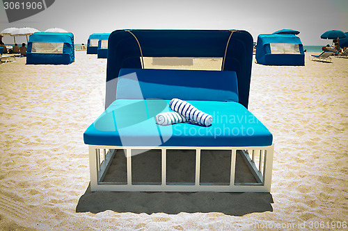 Image of Luxurious beach bed with canopy on a sandy beach