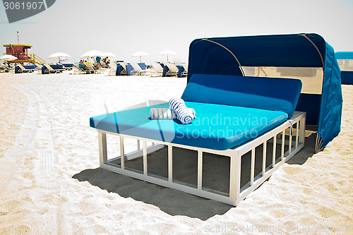 Image of Luxurious beach bed with canopy on a sandy beach