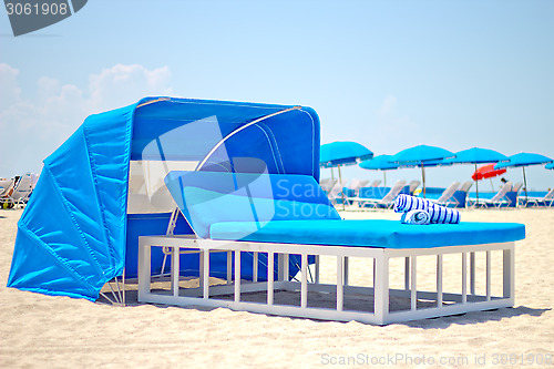 Image of Luxurious beach bed with canopy on a sandy beach