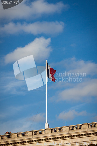 Image of Flag of France fluttering under a serene blue sky