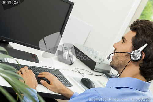 Image of Man wearing headset giving online chat and support