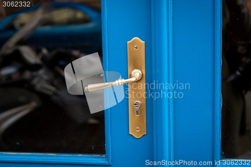 Image of Brass door handle on a colorful blue door