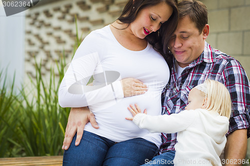 Image of Adorable Baby Girl with Young Pregnant Parents