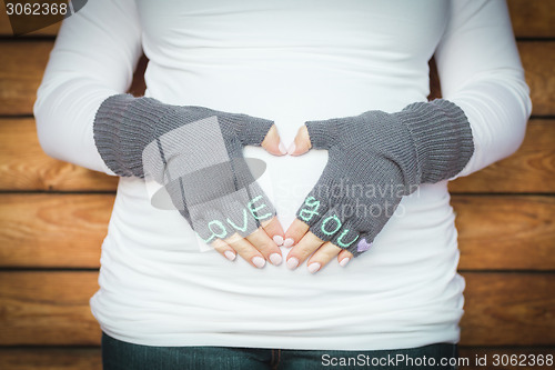 Image of Pregnant Woman Holds Her Stomach with Love You Mittens