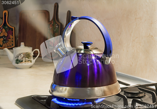 Image of Kettle of boiling water on the flame of the gas stove.