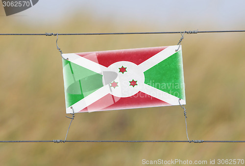 Image of Border fence - Old plastic sign with a flag