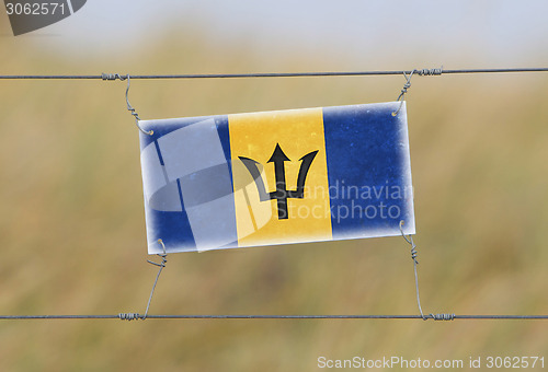 Image of Border fence - Old plastic sign with a flag