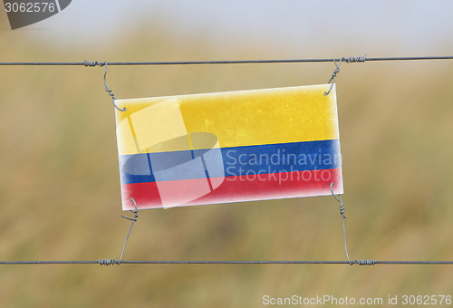 Image of Border fence - Old plastic sign with a flag