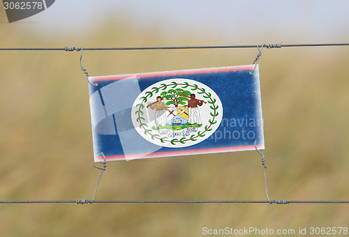 Image of Border fence - Old plastic sign with a flag