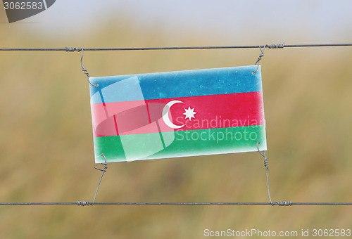 Image of Border fence - Old plastic sign with a flag