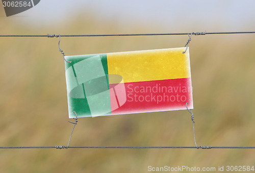 Image of Border fence - Old plastic sign with a flag