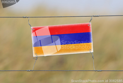 Image of Border fence - Old plastic sign with a flag