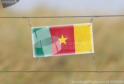 Image of Border fence - Old plastic sign with a flag