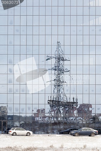 Image of electric pole reflected in windows of office building 