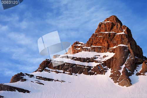 Image of Snowy sunlight rocks at sunrise