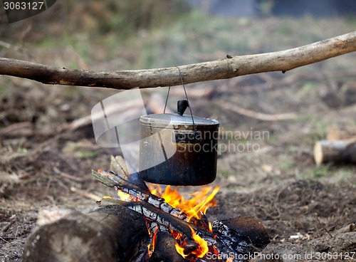 Image of Cooking in sooty cauldron on campfire 