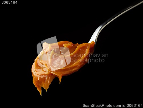 Image of Spoon of melted caramel cream