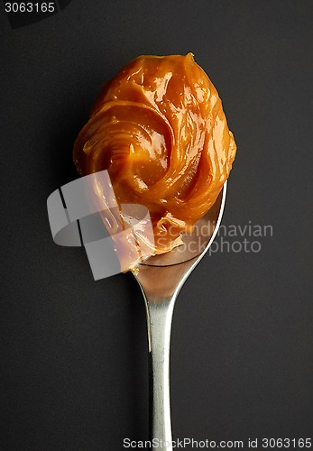 Image of Spoon of melted caramel cream