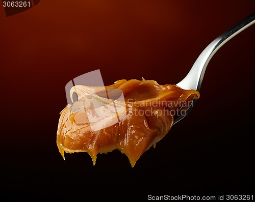 Image of Spoon of melted caramel cream