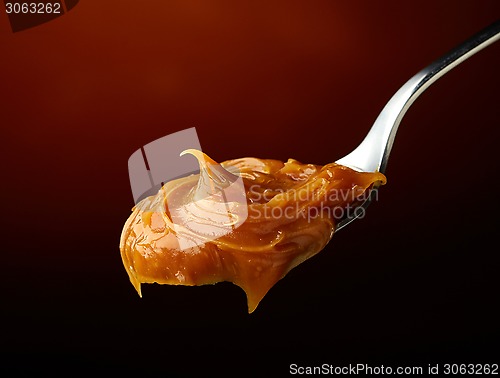 Image of Spoon of melted caramel cream