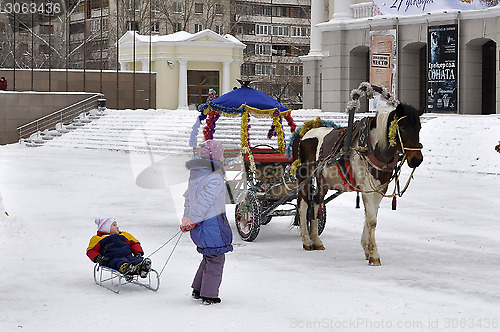 Image of Children stand near a horse with the decorated carriage for driv