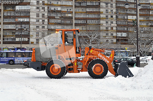 Image of The bulldozer occupied with snow cleaning costs on the street in