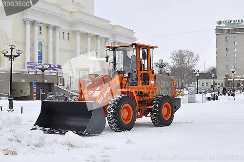 Image of The bulldozer occupied with snow cleaning is on the square near 