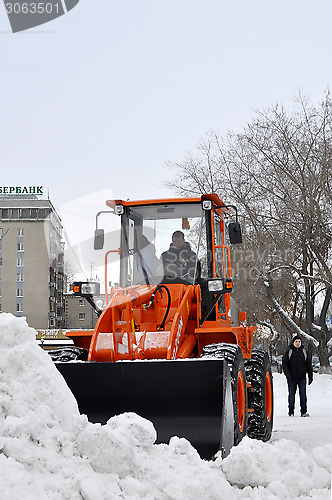 Image of The bulldozer occupied with snow cleaning costs on the street in