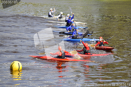 Image of teenagers on kayaks float down the river.