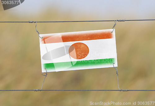 Image of Border fence - Old plastic sign with a flag