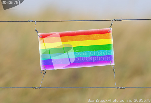 Image of Border fence - Old plastic sign with a flag