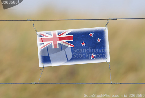 Image of Border fence - Old plastic sign with a flag