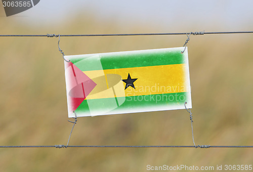 Image of Border fence - Old plastic sign with a flag