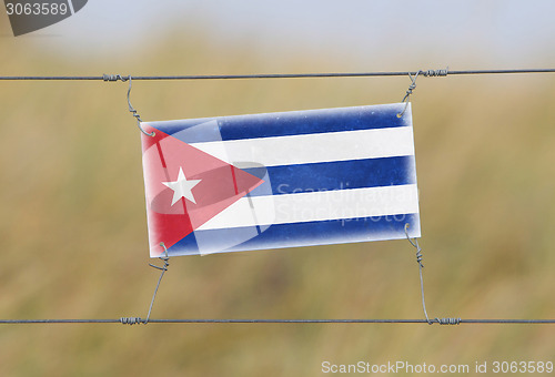 Image of Border fence - Old plastic sign with a flag