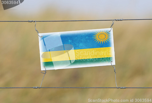 Image of Border fence - Old plastic sign with a flag