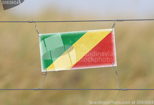 Image of Border fence - Old plastic sign with a flag