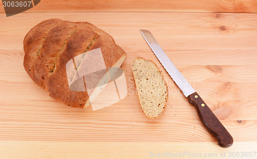 Image of Bread knife with a freshly baked loaf